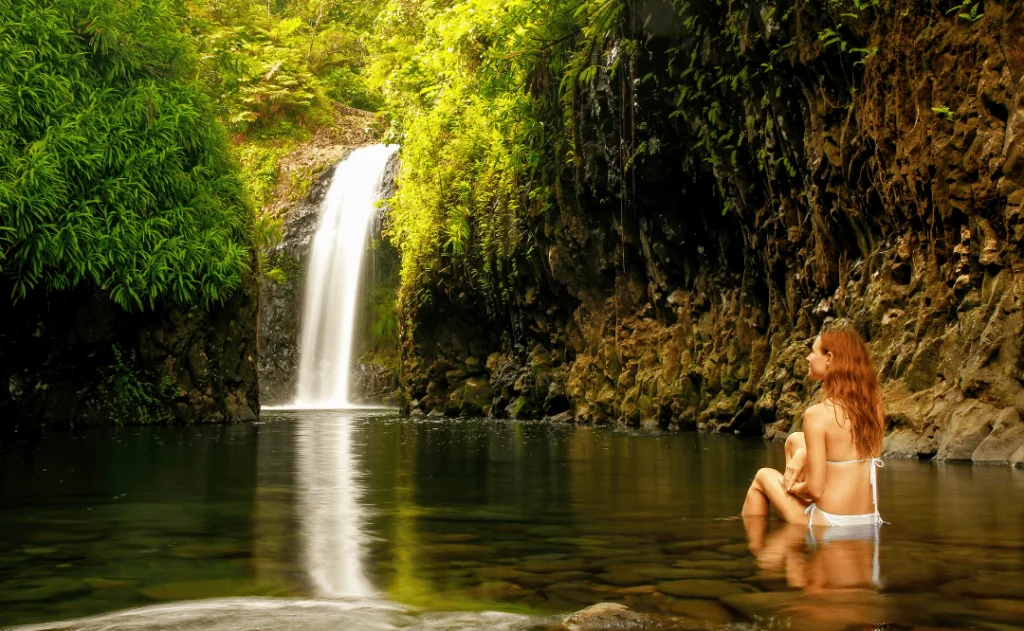 Young woman sitting at Wainibau Waterfall on Taveuni Island, Fiji